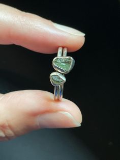 These dainty stacking rings are handmade using 100% genuine Moldavite from Czech Republic and solid Sterling Silver. The raw Moldavite nuggets feature natural deep green color and one of a kind ripples, ridges, and pits of genuine Moldavite. This high vibration gemstone is perfect for manifestation, self help, and making change. Ring sizes: 9 US Stone 1 measures: 4mm wide x 5mm tall (approx.) Stone 2 measures: 6mm wide x 8mm tall (approx.) Moldavite, a rare tektite found only in Czech Republic, Green Sterling Silver Stackable Jewelry, Sterling Silver Stackable Emerald Ring As Gift, Green Hand Forged Jewelry For Anniversary, Green Stackable Minimalist Jewelry, Minimalist Green Stackable Jewelry, Stackable Sterling Silver Emerald Open Ring, Adjustable Stackable Emerald Ring In Sterling Silver, Unique Green Stackable Rings, Stackable Open Emerald Ring In Sterling Silver