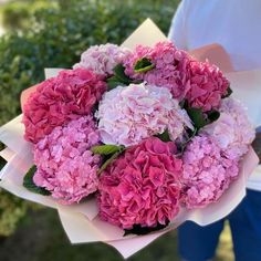 a person holding a bouquet of pink and white flowers