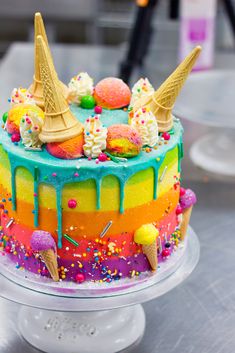 a colorful cake with ice cream and sprinkles on it sitting on a table