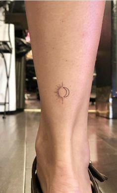 a woman's foot with a small sun and moon tattoo on her left ankle