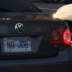 the back end of a black car with a license plate