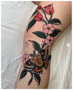 a woman's leg with flowers and butterfly tattoo on the side of her arm