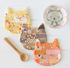 three baby bibs and a wooden spoon on a table