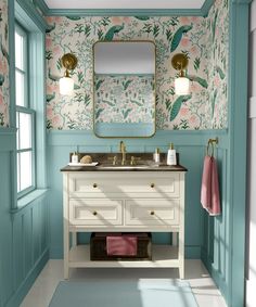 a bathroom with floral wallpaper and blue walls