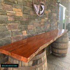 a wooden bench sitting next to two wine barrels