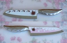 two knives with floral designs on them are sitting on a pink and white tablecloth