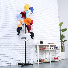 a white brick wall behind a black metal stand with various pairs of shoes on it