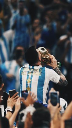 a man holding up a trophy in front of a crowd