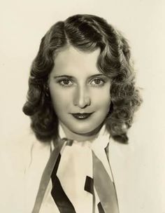 an old black and white photo of a woman wearing a tie