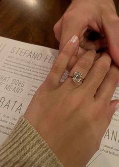 a close up of a person's hand with a ring on top of a piece of paper