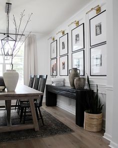 a dining room table with chairs and pictures on the wall