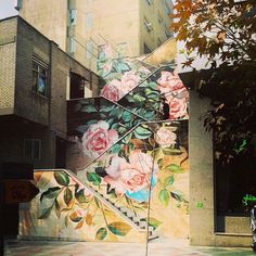 there is a mural on the side of a building with roses painted all over it