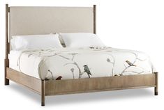 a bed with two birds on the headboard and white linens, in front of a white background