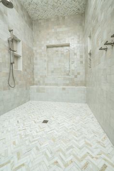 a white tiled bathroom with shower head and hand held faucet in the corner