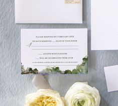 the wedding stationery is laid out with flowers