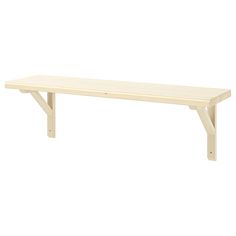 a wooden bench sitting on top of a white wall