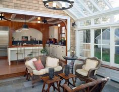 a living room filled with furniture next to a kitchen