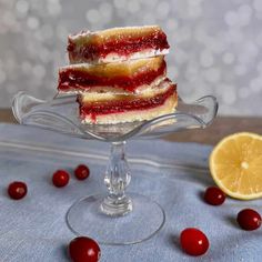 three pieces of cake sitting on top of a glass plate with cherries around it