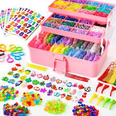 a pink plastic box filled with lots of colorful beads and accessories next to other items