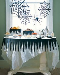 the table is decorated with spider webs and cupcakes