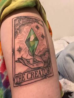 a person with a tattoo on their arm that reads the creator and is holding a green diamond