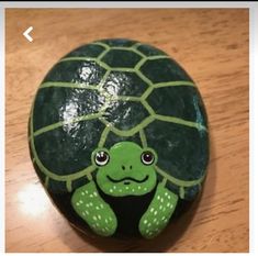 a painted turtle sitting on top of a wooden table