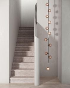 the stairs are lined with metal balls and hanging from the ceiling in this modern home