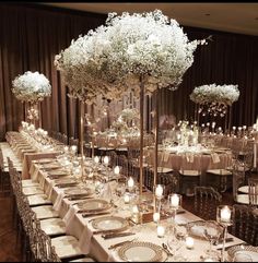 the tables are set up with white flowers and candles for an elegant dinnereone