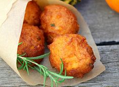 some fried food sitting on top of a piece of wax paper next to an orange