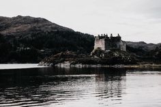 an old castle sitting on top of a small island in the middle of a lake