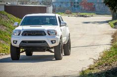 a white truck driving down a dirt road