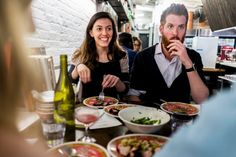 two people sitting at a table with plates of food