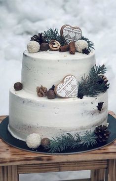 a three tiered cake decorated with pine cones and ornaments