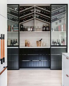 a wine cellar with many bottles and glasses on the shelves