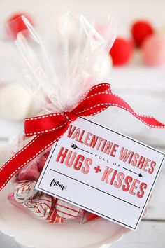 a valentine's day gift bag with hugs and kisses in it on a plate