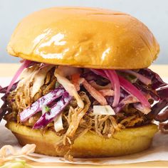 a pulled pork sandwich with coleslaw and onions