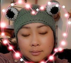 a woman wearing a knitted hat with lights in the shape of a heart