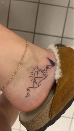 a woman's foot with a small tattoo on it