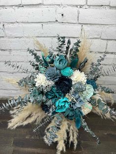 a bridal bouquet with blue flowers and feathers