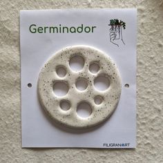 a white button with holes in the middle on a piece of paper that says germinoor