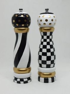 two black and white checkered salt and pepper shakers with gold trimmings