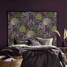 a bedroom with purple walls and a floral headboard on the wall above the bed