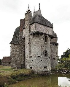 an old castle with two towers next to a body of water