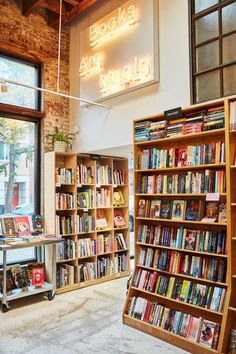 there are many books on the shelves in this room and one has a neon sign above it