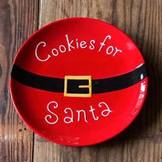 a red santa claus plate with cookies for santa written on it