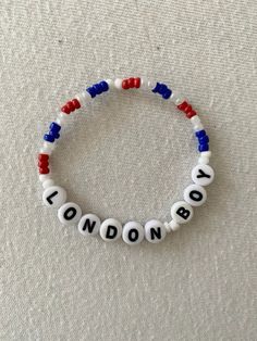 a bracelet with the word london written in white and red beads on top of it