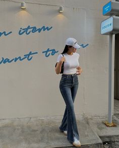 a woman standing on the side of a building next to a sign that says don't stop, i want to go