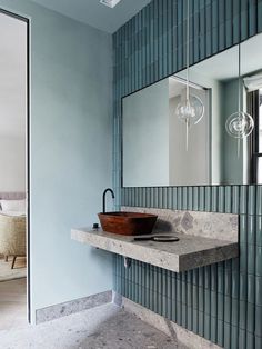 a bathroom sink sitting under a mirror next to a counter top with a bowl on it