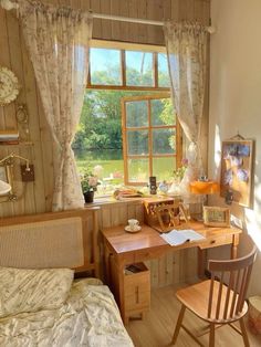 a bedroom with a bed, desk and chair in it next to a large window