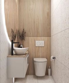 a white toilet sitting next to a sink in a bathroom under a wooden paneled wall